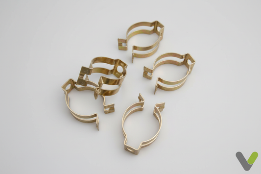 Nibe Hose Lock Clips 028145 - pack of 4 brass spring clips on light grey background with Varmetec V logo